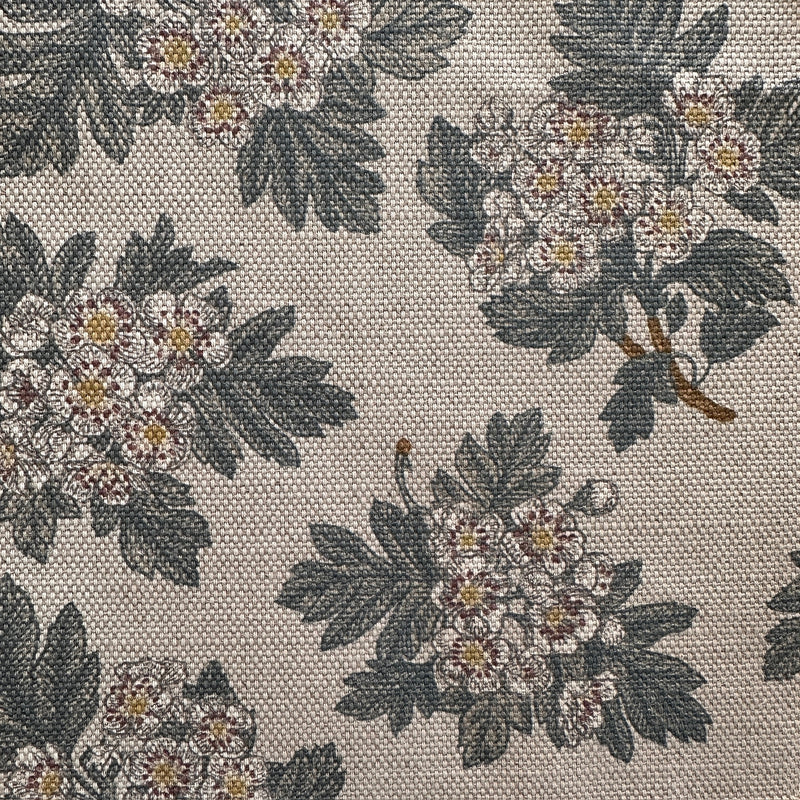 Floral patterned fabric with dark green leaves and light-colored flowers on a neutral background